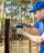 fencing services - worker installing welded metal mesh fence