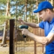 fencing services - worker installing welded metal mesh fence